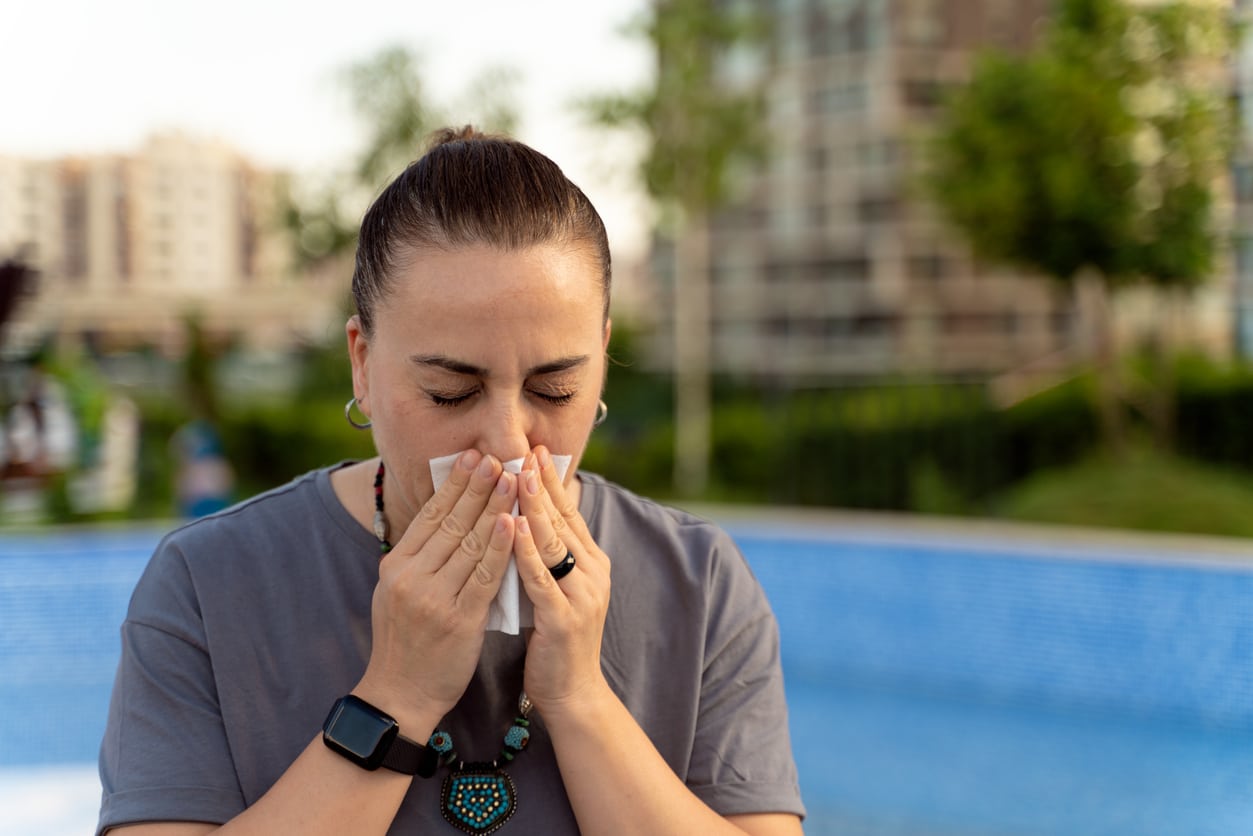 Woman blows nose in park