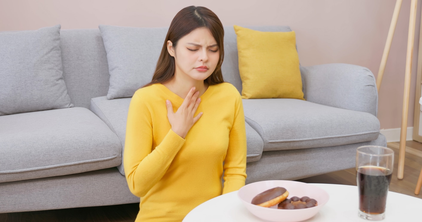 Woman with acid reflux holding her throat